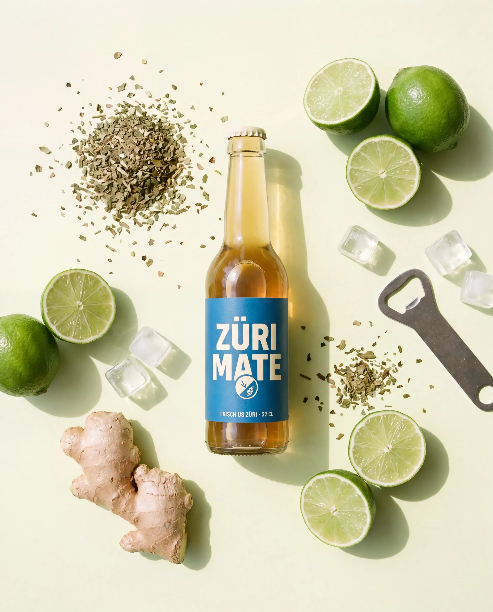Züri Mate Flasche zwischen Limetten, Ingwer und Mateblättern
